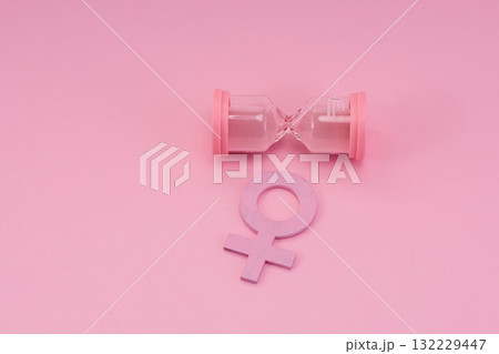 Hourglass with the female gender symbol. Women's health, menopause concept. 132229447