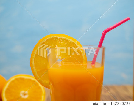 Fresh juice, mix fruits, orange drink on a blue background. Glass with orange cocktail. Fresh juice, mix fruits, orange drink on a blue background. Glass with orange cocktail. 132230728
