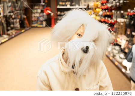 A child wearing a dog mask at a store on Halloween 132230976