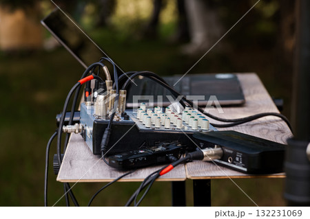 Outdoor Audio Setup with Mixer, Recorder, and Microphones on Wooden Table in Lush Green Forest Environment, Professional Recording. 132231069