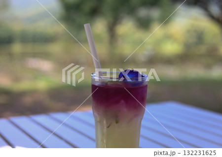 Refreshing butterfly pea lemonade drink on white table outdoor 132231625