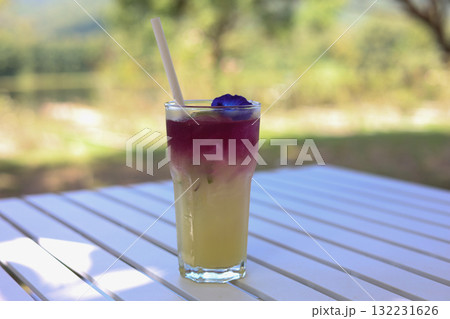 Refreshing butterfly pea lemonade drink on white table outdoor Refreshing butterfly pea lemonade drink on white table outdoor 132231626