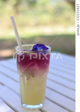 Refreshing butterfly pea lemonade drink on white table outdoor 132231627