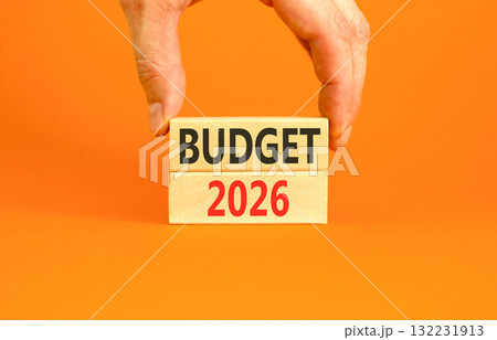 Budget 2026 symbol. Concept words Budget 2026 on beautiful wooden blocks. Beautiful orange paper background. Businessman's hand. Business and budget 2026 concept. Copy space. 132231913