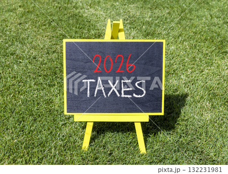 2026 taxes new year symbol. Concept words 2026 taxes on beautiful black blackboard. Beautiful green grass background. Business and 2026 taxes new year concept. Copy space. 132231981