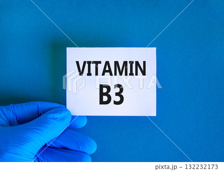 Vitamin B3 niacin symbol. Concept words Vitamin B3 on beautiful white card. Doctor's hand in blue medical glove. Beautiful blue background. Medical healthy lifestyle Vitamin B3 niacin concept. 132232173