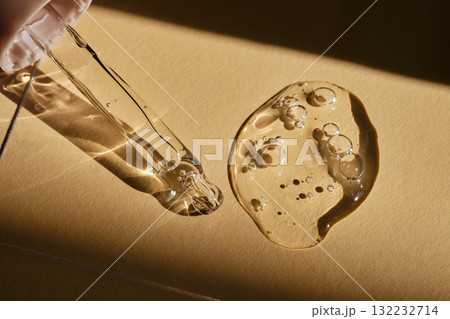 A pipette with cosmetic serum on a beige background. 132232714