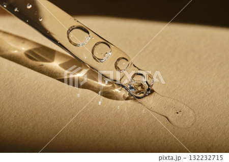 A pipette with cosmetic serum on a beige background. 132232715
