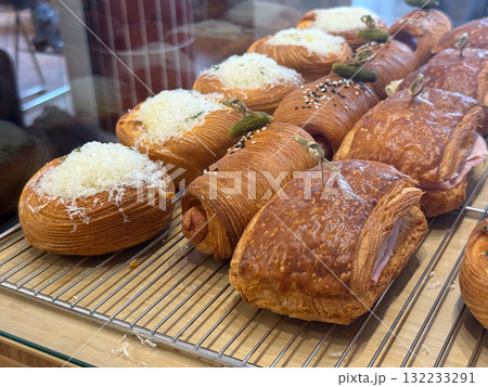 Assorted croissants and pastries with cheese and ham. Savory flavor, texture, and artisanal baking in modern cafe display. Assorted croissants and pastries with cheese and ham. Savory flavor, texture, and artisanal baking in modern cafe display. 132233291