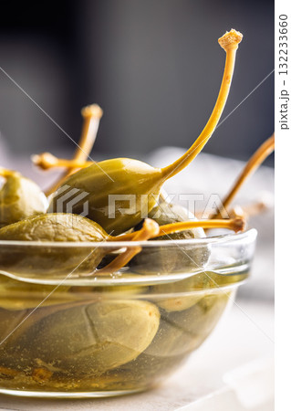 Pickled capers berries in bowl on white table 132233660