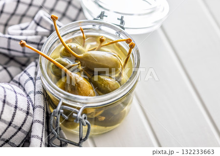 Pickled capers berries in bowl on white table 132233663