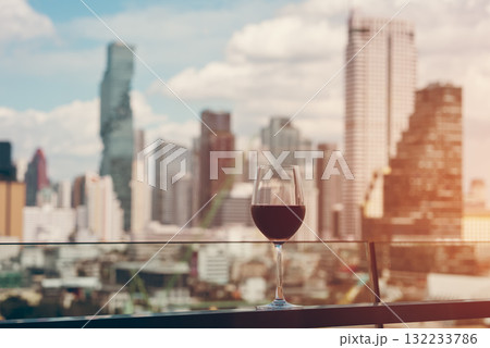 red wine on terrace with Bangkok city skyline at sunset, cocktail on rooftop, vibrant cityscape and luxury panorama view 132233786