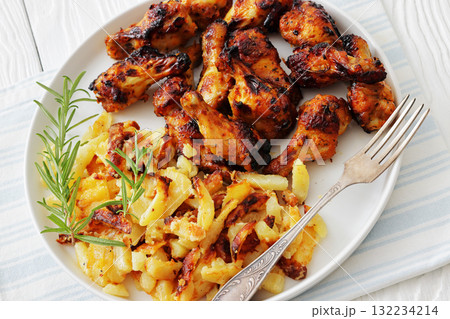 bbq chicken wings with fried potatoes on plate bbq chicken wings with fried potatoes on plate 132234214