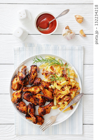 bbq chicken wings with fried potatoes on plate bbq chicken wings with fried potatoes on plate 132234218