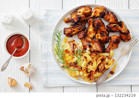 bbq chicken wings with fried potatoes on plate bbq chicken wings with fried potatoes on plate 132234219