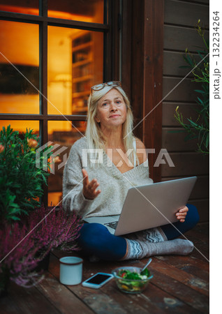 Older woman having dinner while working from homeoffice. 132234264