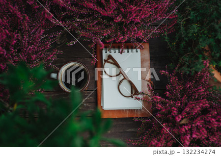 Reading glasses resting on notebook in autumn garden Reading glasses resting on notebook in autumn garden 132234274