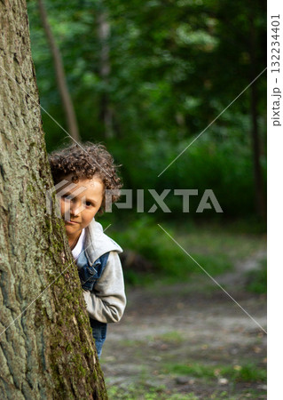 Curious Boy Exploring Nature in Park. 10 year old boy exploring something. His focused expression captures wonder of childhood discovery and learning about the natural world. High quality 132234401