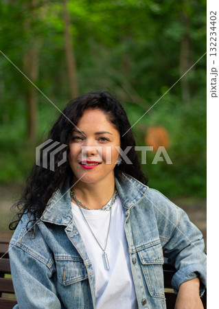 Happy young female with curly hair enjoying sunny day in nature. Captures essence of happiness, freedom, and enjoying simple pleasures outdoors Happy young female with curly hair enjoying sunny day in nature. Captures essence of happiness, freedom, and enjoying simple pleasures outdoors 132234402