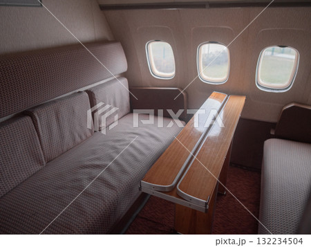 cozy relaxing nook, comfortable lounge with convenient table, relaxing seating area with foldout table nearby, an inviting lounge with reclining seats and nearby foldout table 132234504