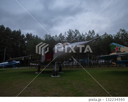 weathered soviet interceptor in outdoor museum, old soviet aircraft parked in aviation museum under cloudy sky, vintage soviet interceptor resting on grassy field during moody weather 132234593