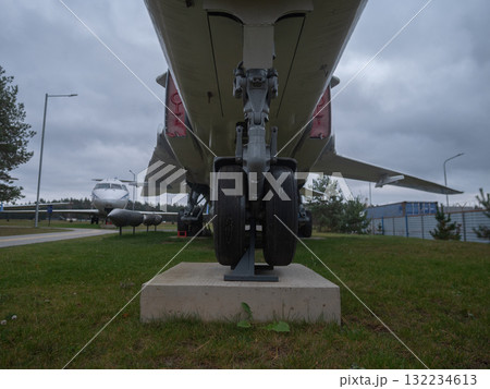 jet gear closeup, detailed airplane landing gear view, aircraft landing gear detailed view against cloudy sky backdrop, closeup of airplane landing gear with tarmac and cloudy sky background jet gear closeup, detailed airplane landing gear view, aircraft landing gear detailed view against cloudy sky backdrop, closeup of airplane landing gear with tarmac and cloudy sky background 132234613