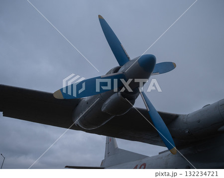 blue propeller closeup overcast sky, metallic hub and fuselage edge, dramatic low-light mood, rain-slick paint and visible rivets conveying industrial power and vintage engineering blue propeller closeup overcast sky, metallic hub and fuselage edge, dramatic low-light mood, rain-slick paint and visible rivets conveying industrial power and vintage engineering 132234721