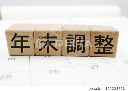 カレンダー背景に並ぶ木のブロックと年末調整の文字イメージ。 カレンダー背景に並ぶ木のブロックと年末調整の文字イメージ。 132235868
