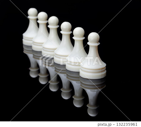 Symmetrical lineup of white chess pieces on reflective surface, symbolizing strategy, balance and competition. 132235961