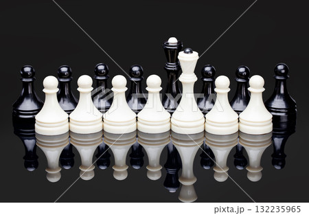 Symmetrical lineup of white chess pieces on reflective surface, symbolizing strategy, balance and competition. 132235965