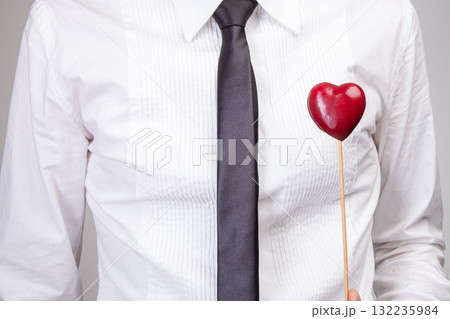 Portrait charming man hold hand card heart gift casual style shirt isolated over grey color background Portrait charming man hold hand card heart gift casual style shirt isolated over grey color background 132235984