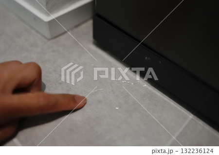 冷蔵庫下部（冷凍室）からの水漏れトラブルで床が濡れている様子。 132236124