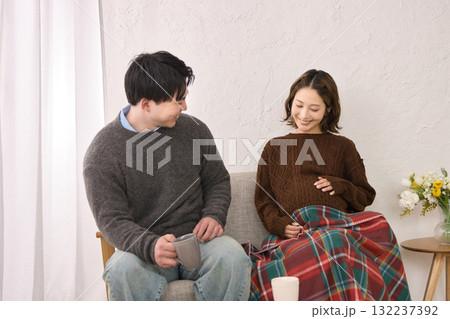 ソファに座ってくつろぐ若い夫婦　妊婦さん 132237392