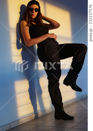 Teenage model posing in urban sunset, ideal for fashion photography and youth lifestyle ads. Teenage model posing in urban sunset, ideal for fashion photography and youth lifestyle ads. 132237576