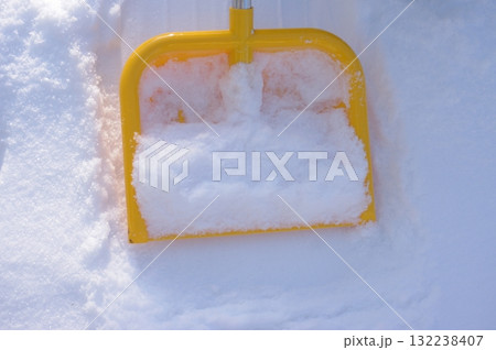 Yellow snow shovel is sitting in the snow Yellow snow shovel is sitting in the snow 132238407