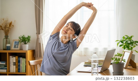 デスク横でストレッチをする在宅ワークの女性 デスク横でストレッチをする在宅ワークの女性 132238603
