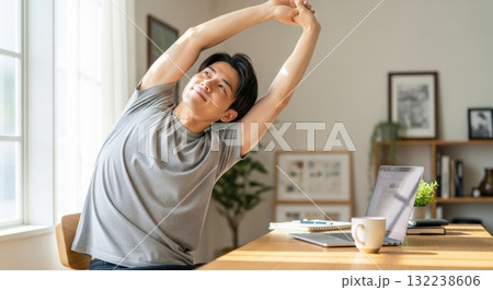 デスク横でストレッチをする在宅ワークの女性 132238606