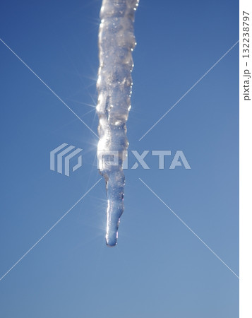 A long icicle hanging from the sky 132238797