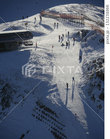 A ski slope with a lot of people skiing down it 132238866