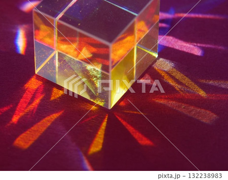 Cube of glass is sitting on a red surface Cube of glass is sitting on a red surface 132238983