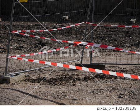 Red and white striped rope is tied to a metal fence 132239139