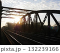 Train is crossing a bridge with a sun shining on it 132239166