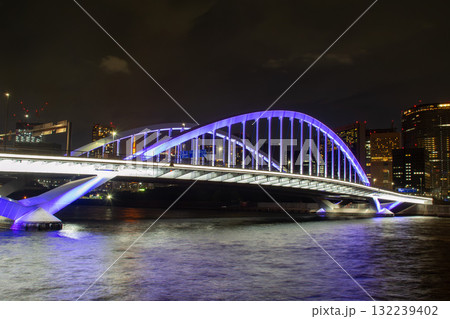 青く輝く夜の築地大橋と隅田川の夜景 132239402
