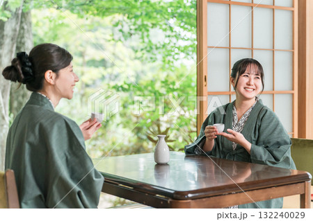 日本旅館の和室の縁側で浴衣姿で日本酒を飲む女性・友人 132240029