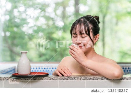 温泉に入りながら日本酒を飲む若いアジア人女性 132240227