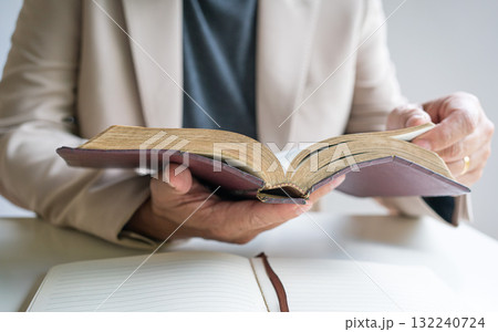 Preacher holding an open old rustic bible in his hands. Preacher holding an open old rustic bible in his hands. 132240724