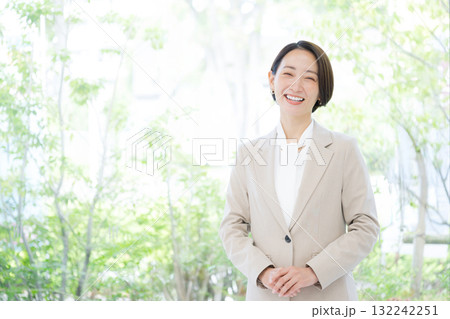 パソコンを持つスーツの女性 コンサルタント、リクルートなど転職のイメージ　笑顔でカメラ目線	 132242251