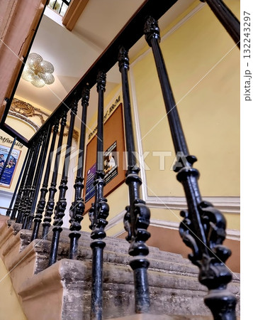 Historic interior staircase in a Saint Petersburg building, showing elegant black cast-iron railings and warm yellow walls. Historic interior staircase in a Saint Petersburg building, showing elegant black cast-iron railings and warm yellow walls. 132243297