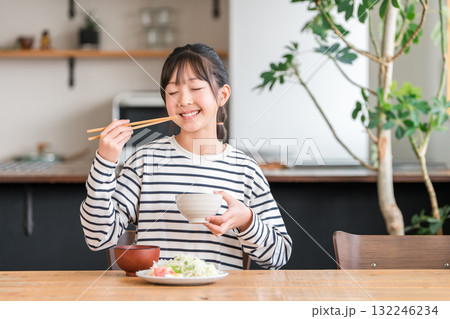 食卓・ダイニングテーブルで食事する小学生,中学生の女の子（ランチ,朝食,ご飯,食べる） 132246234