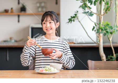 食卓・ダイニングテーブルで食事する小学生,中学生の女の子（ランチ,朝食,ご飯,食べる） 132246238